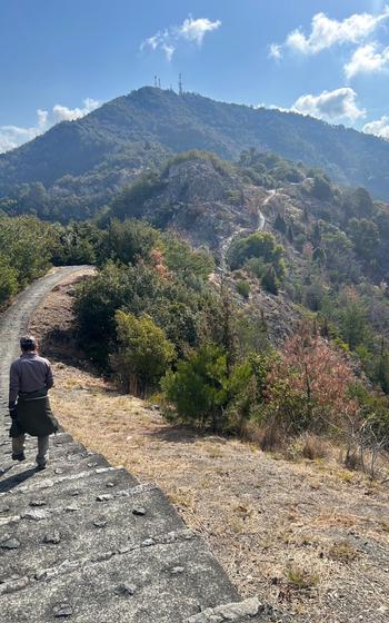 a man walking on a trail of an island mountain of the Seto Inland Sea